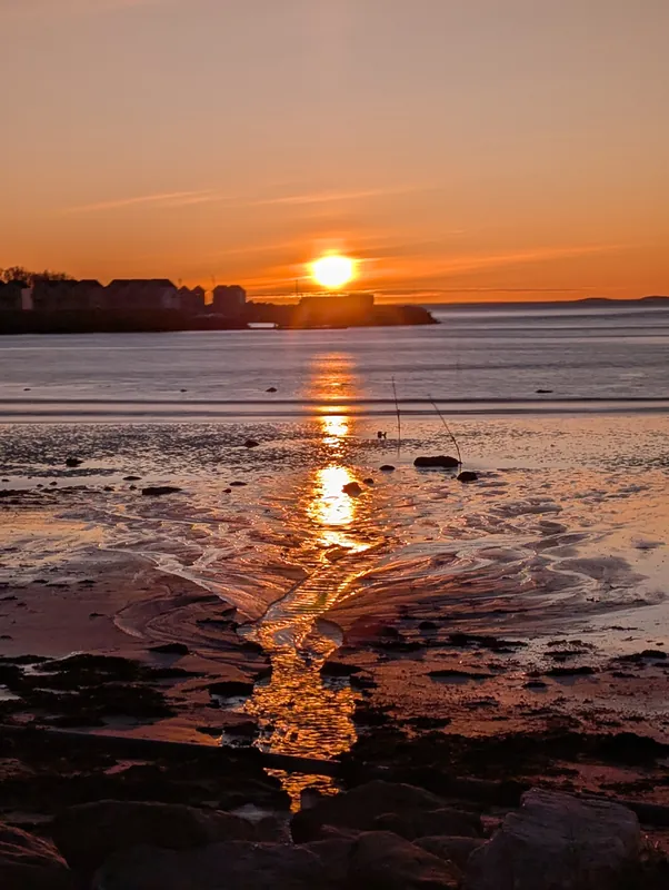 Coucher de soleil magique sur la plage de Mjellestranda près de Bodø, reflets orangés sur le sable mouillé — un des plus beaux moments du voyage.