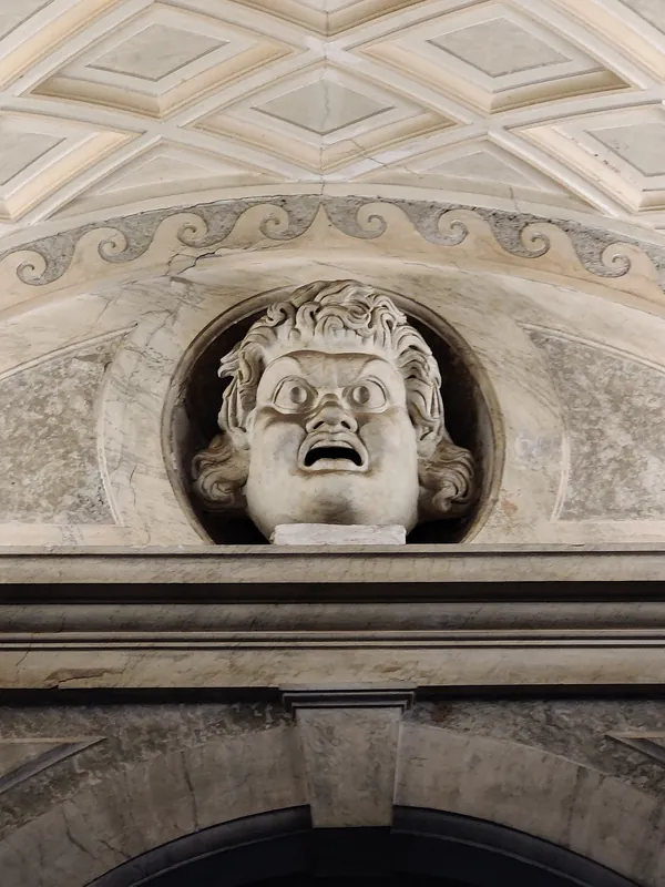 Immense masque antique à la bouche ouverte niché dans une arche du Musée du Vatican à Rome
