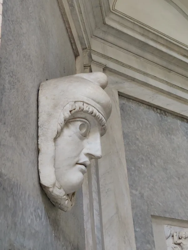 Sculpture murale en marbre d'une tête antique coiffée d'un casque vue de profil au Musée du Vatican