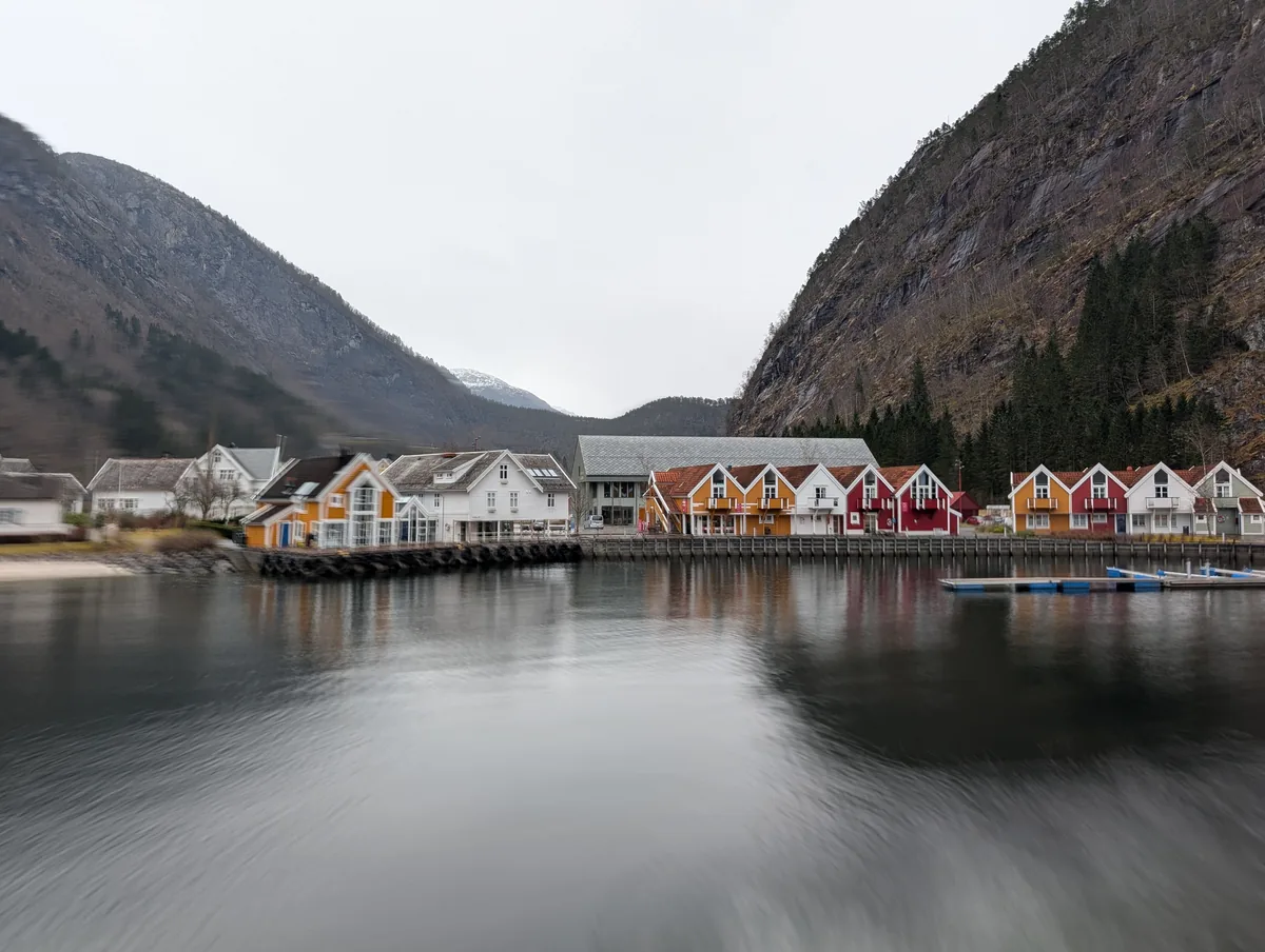 Quai de Modalen et maisons en pose longue Quai de Modalen et alignement de maisons traditionnelles rouges, jaunes et blanches en pose longue, demi-tour de la croisière Mostraumen.