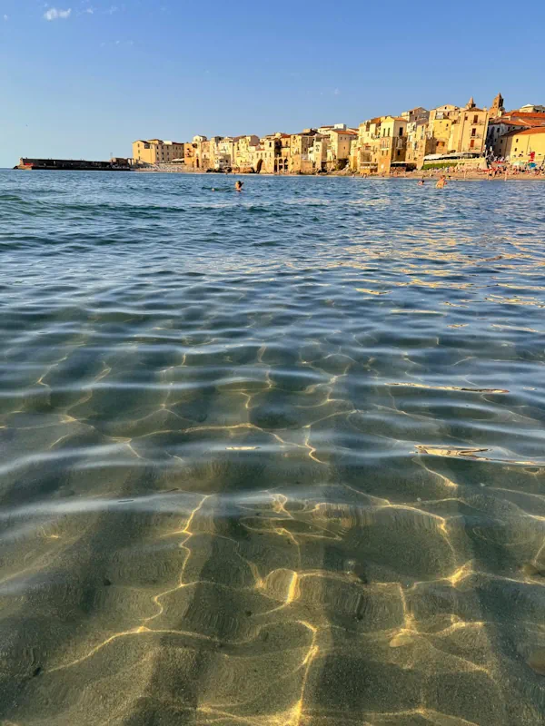 Playa de Cefalù en Sicilia con agua turquesa paradisíaca Playa de Cefalù en Sicilia con agua turquesa paradisíaca