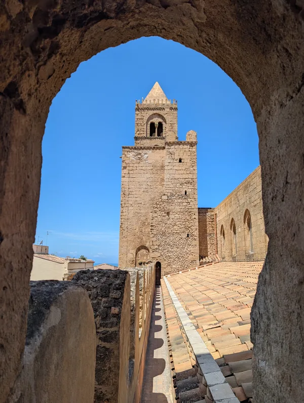Campanario de la catedral de Cefalù enmarcado por un arco de piedra Campanario de la catedral de Cefalù enmarcado por un arco de piedra