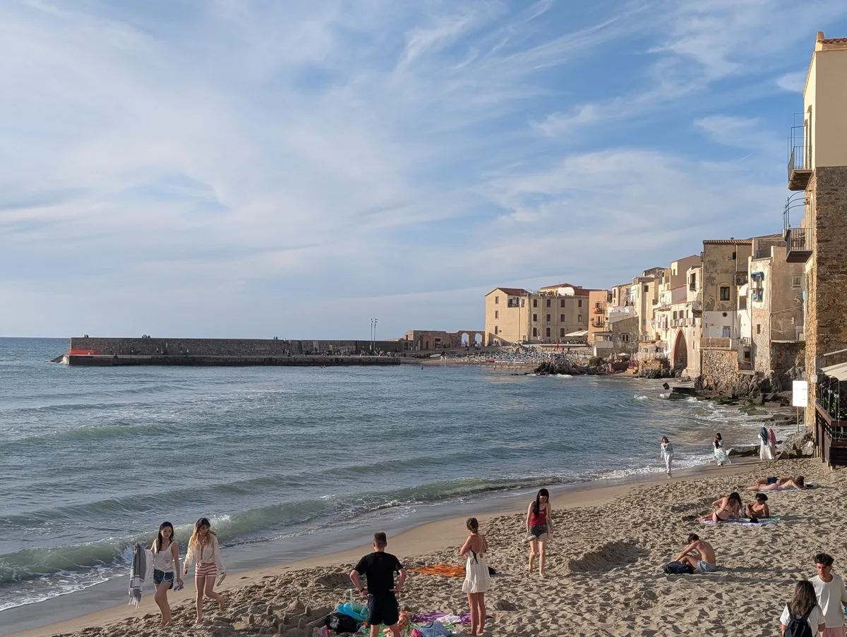 Vista panorámica de la playa de Cefalù al final de la tarde con la Rocca Vista panorámica de la playa de Cefalù al final de la tarde con la Rocca