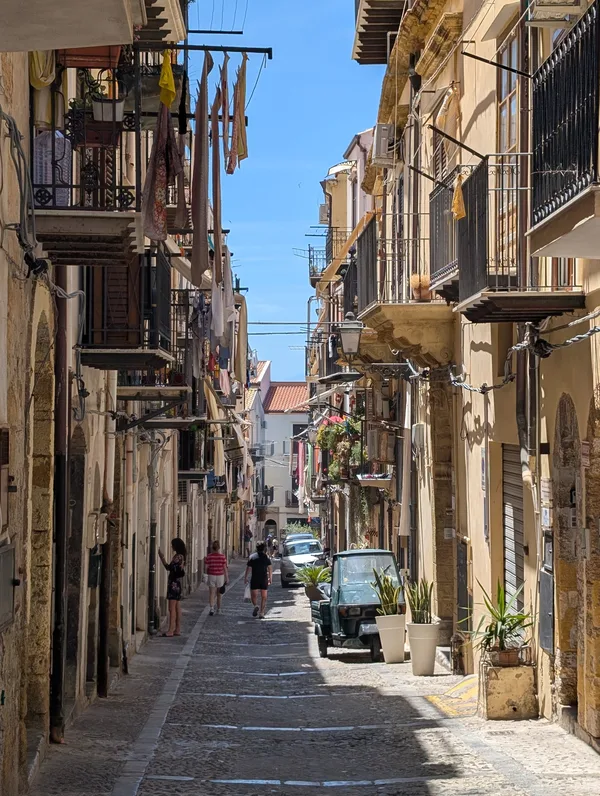 Callejuela animada del centro histórico de Cefalù bajo cielo azul Callejuela animada del centro histórico de Cefalù bajo cielo azul