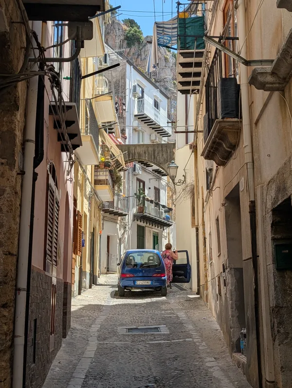 Callejuela estrecha hacia la Rocca en Cefalù con coche antiguo Callejuela estrecha hacia la Rocca en Cefalù con coche antiguo