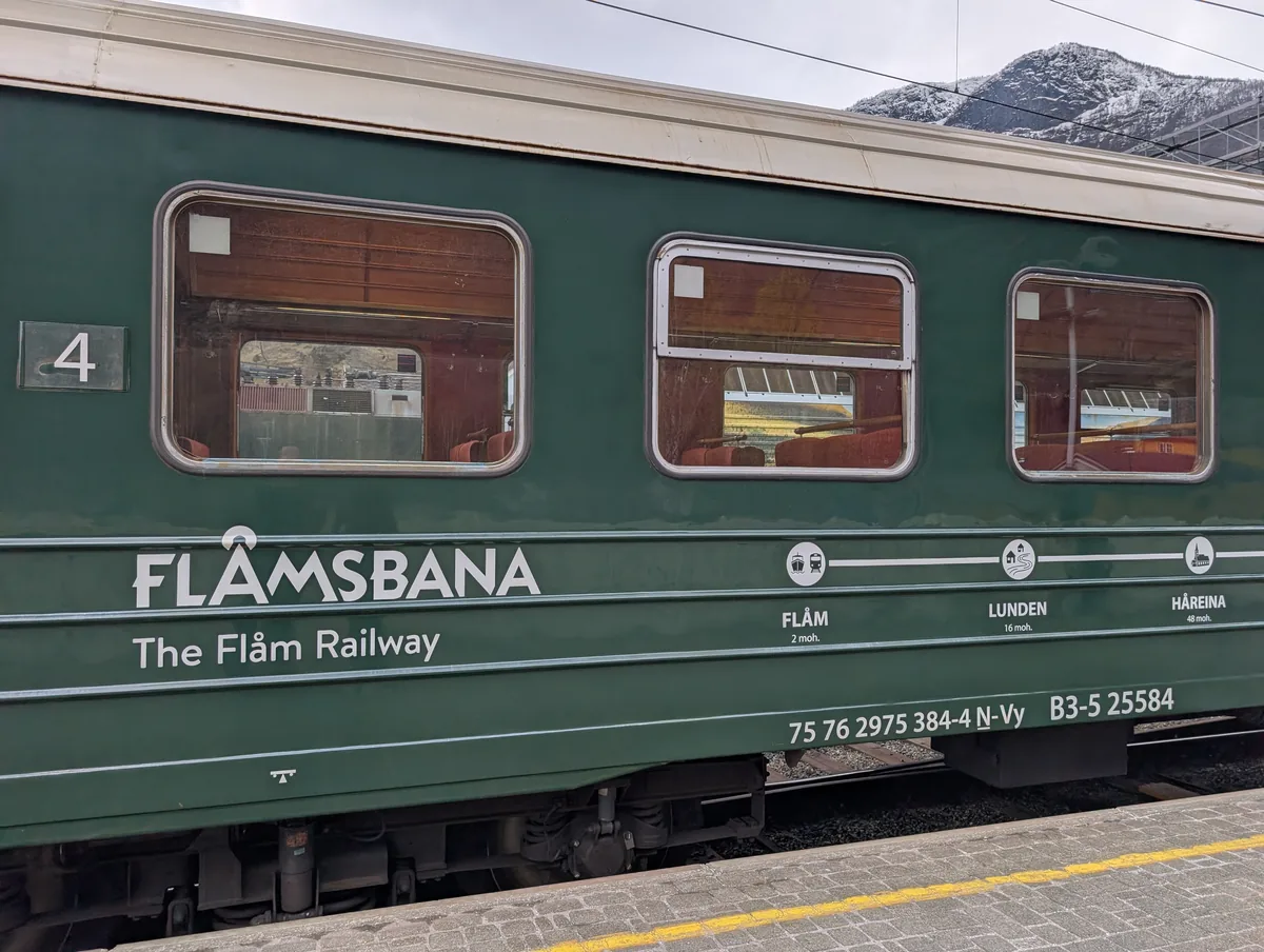 Wagon vert numéro 4 du train de Flåm portant l'inscription Flåmsbana The Flåm Railway, à quai en gare de Flåm.