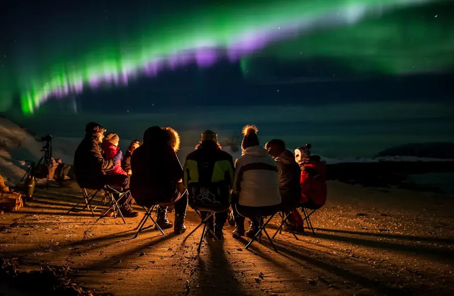 Green northern lights above the fjords near Tromsø with Northern Horizon