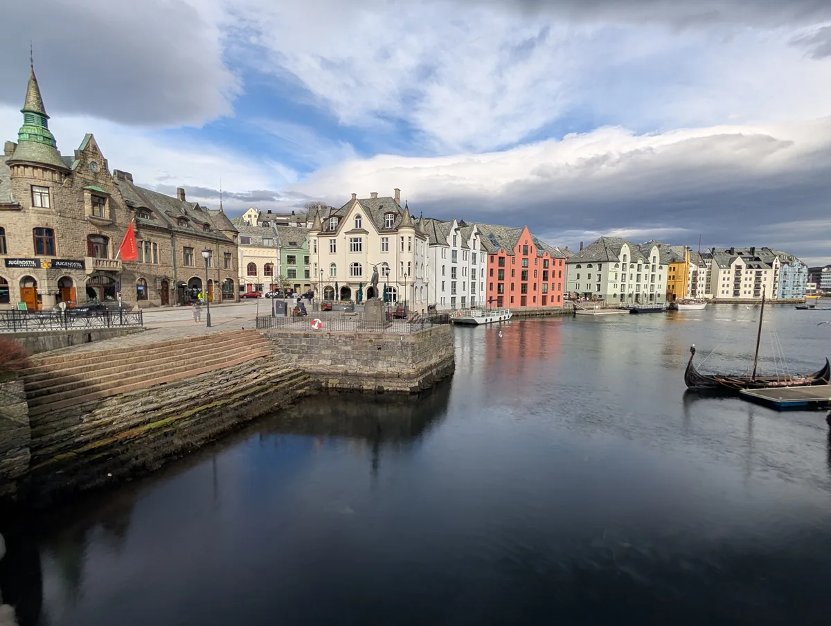Canal Brosundet et musée Jugendstil à Ålesund Vue panoramique du canal Brosundet à Ålesund avec le musée Jugendstilsenteret et un drakkar viking amarré, en Norvège.