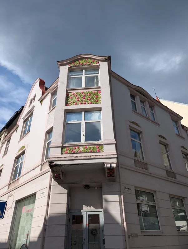 Façade Art nouveau ornée de roses à Ålesund Façade Art nouveau rose décorée de reliefs de roses et de feuillages à l'angle de Kirkegata et Hellegata à Ålesund.