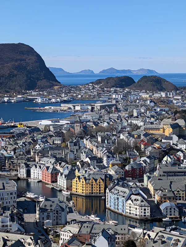 Panorama du Mont Aksla sur Ålesund Panorama depuis le Mont Aksla sur les entrepôts colorés d'Ålesund, le fjord et les montagnes enneigées en Norvège.
