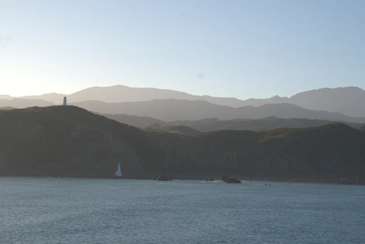 White lighthouse perched on the rocky point marking the entrance to Tory Channel, the passage the ferry takes towards Picton.