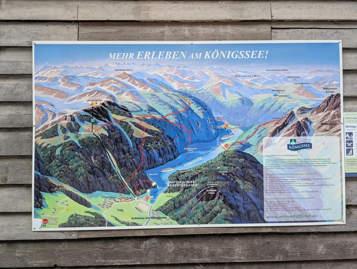 Carte du Königssee à l'embarcadère de Schönau Panneau d'orientation illustré présentant le Königssee, l'Obersee et St. Bartholomä à l'embarcadère de Schönau, en Bavière.