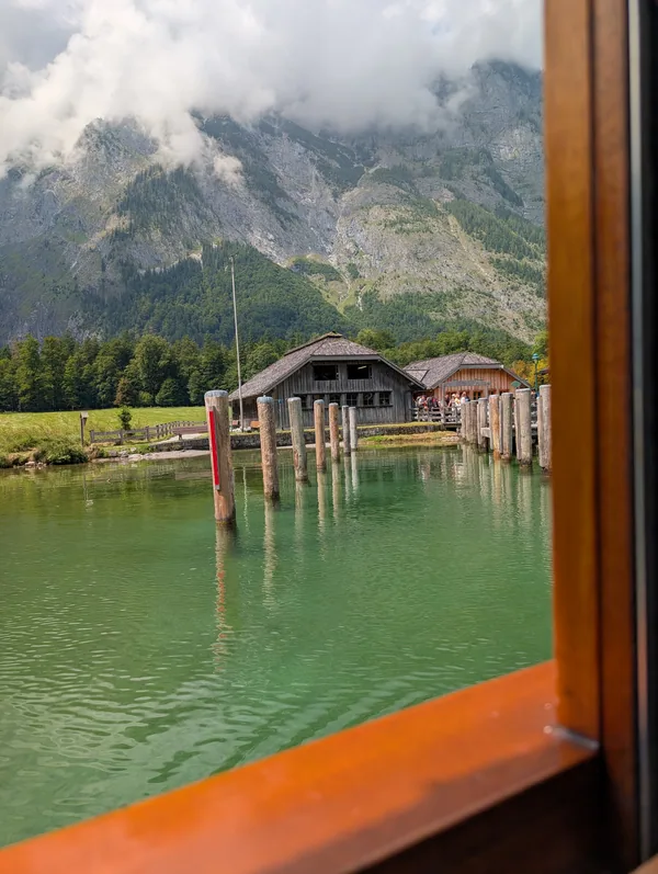 Hangar à bateaux vu du bateau du Königssee Hangar à bateaux en bois encadré par la fenêtre ouverte d'un bateau électrique du Königssee, en Bavière.