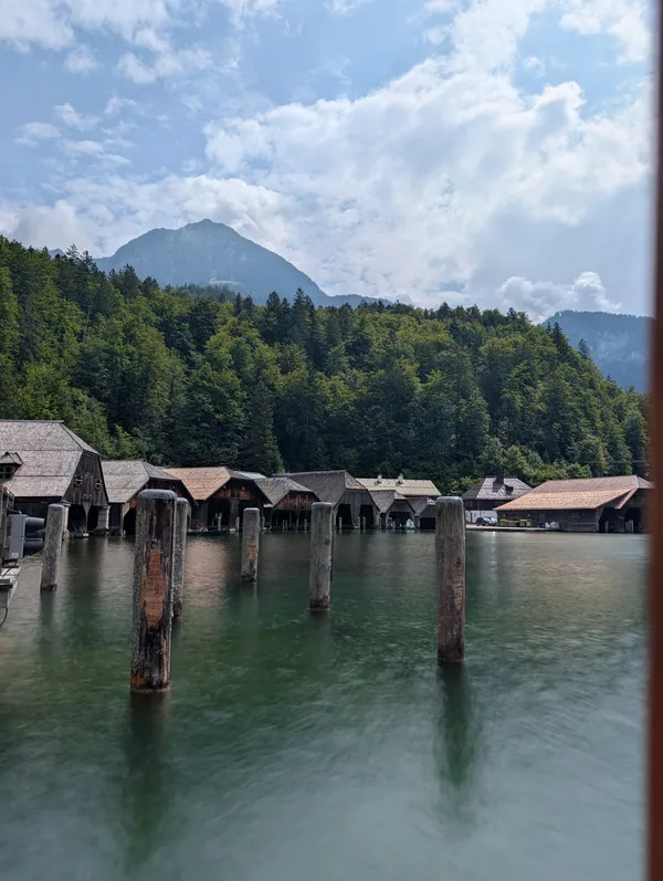 Hangars sur pilotis au bord du Königssee Rangée de hangars à bateaux montés sur pilotis au-dessus de l'eau vert émeraude du Königssee, en Bavière.