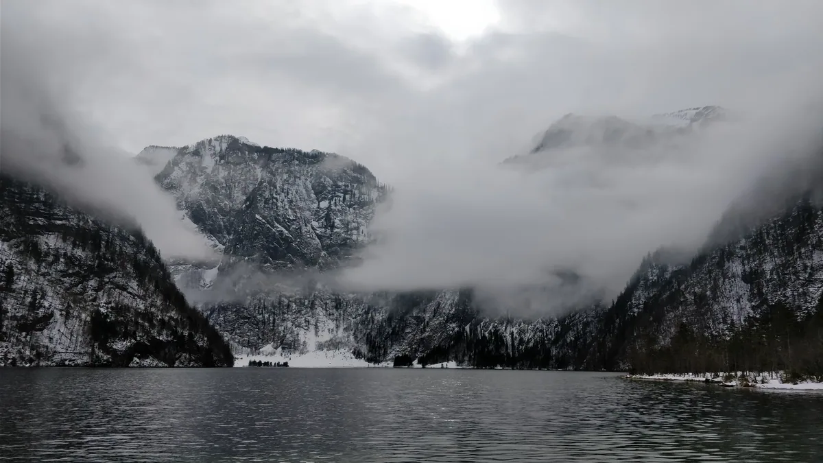 Le Königssee en hiver sous les nuages Nuages déchirés accrochés aux parois enneigées du Königssee en plein hiver, quand le lac est presque désert.