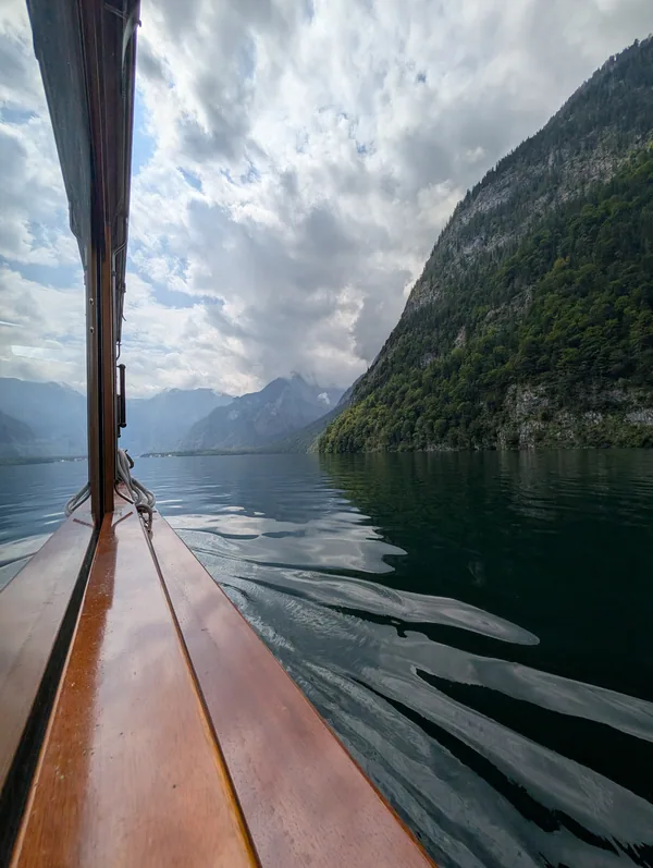 Proue du bateau sur le Königssee Proue en bois verni d'un bateau du Königssee fendant l'eau sombre, entre les parois rocheuses du parc national.