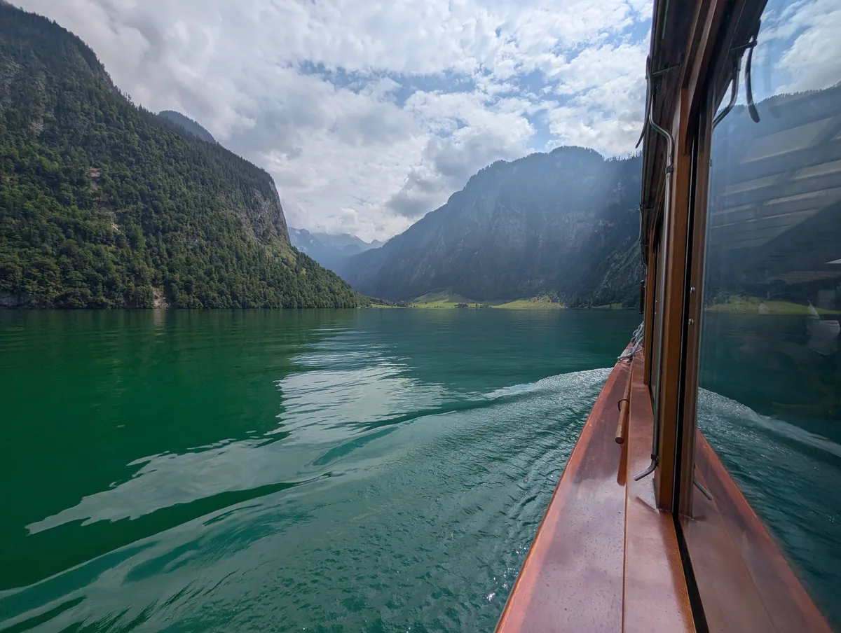 Sillage du bateau sur le Königssee Sillage du bateau électrique traçant une ligne claire sur l'eau verte du Königssee, entre les montagnes bavaroises.
