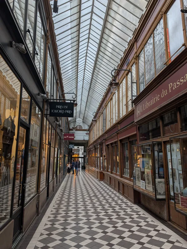Antiquarian bookshop in a Parisian covered passage Wooden shopfronts and an antiquarian bookshop beneath the glass roof of a covered passage of the Grands Boulevards, black-and-white chequerboard floor in Paris.