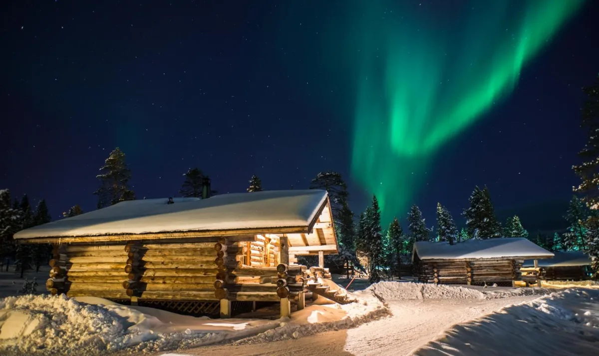 Cabaña de troncos Arctic Log Cabins bajo la nieve y las auroras boreales en Saariselkä, en la Laponia finlandesa