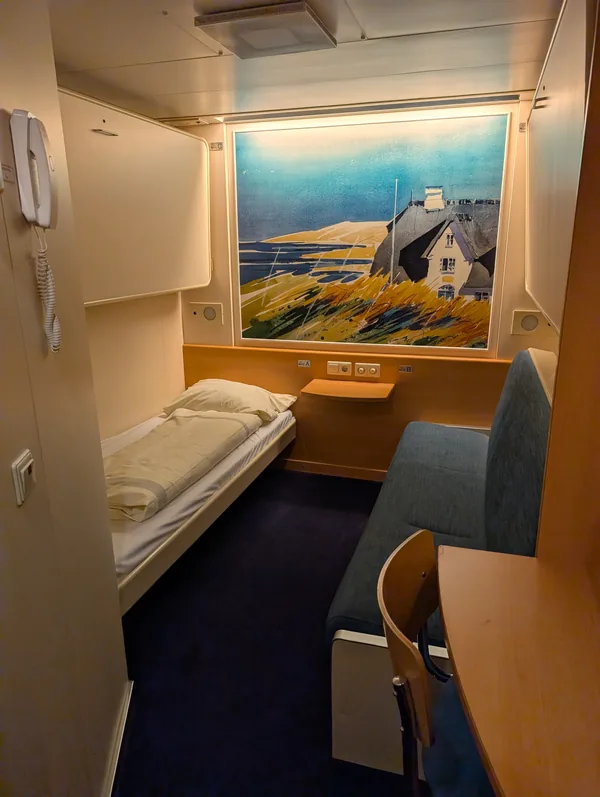 Einfache Innenkabine der TT-Line-Fähre Tinker Bell mit Bett, Sitzbank, kleinem Schreibtisch und Seekarte, für die Nacht nach Schweden