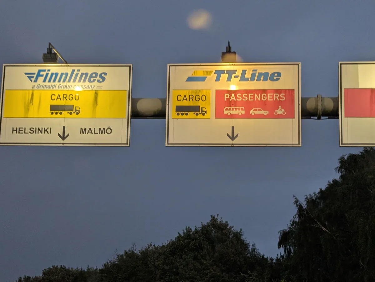 Wegweiser von TT-Line und Finnlines an der Einfahrt zum Hafen Travemünde, mit den Spuren für Pkw und Fracht nach Schweden und Finnland