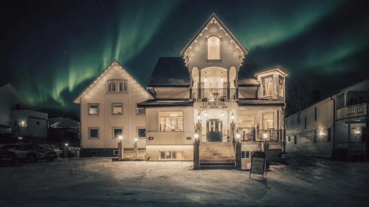 Villa blanche du Havblikk Boutique Hotel à Tromsø sous les aurores boréales, à 300 mètres de la cathédrale arctique